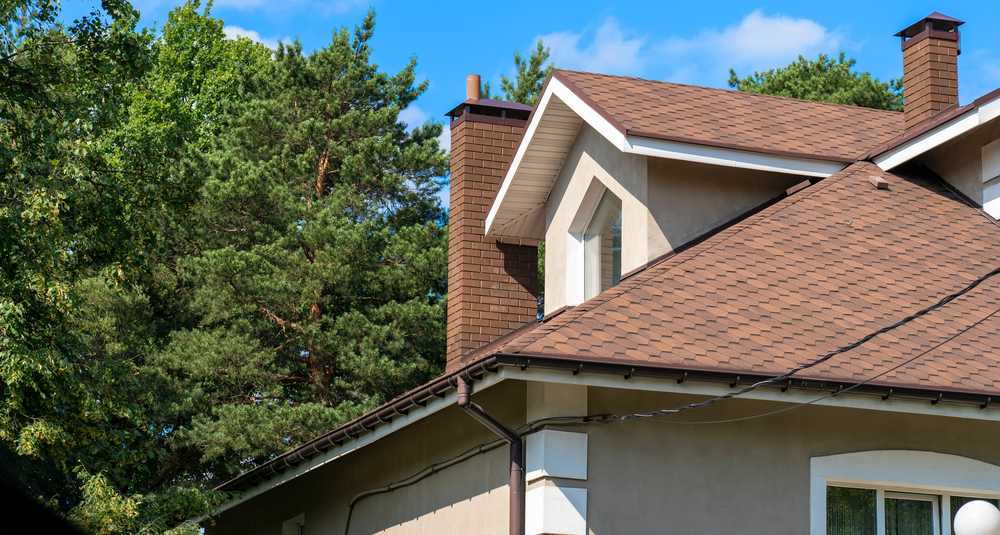 Close up,of,asphalt,shingled,roofing,construction,with,chimney,,plastic,soffit,
